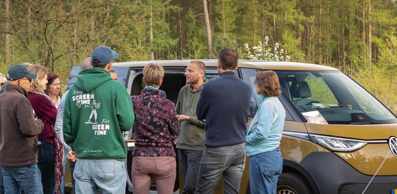Bezoekers rond een Outbase campervan tijdens de Outbase Rally