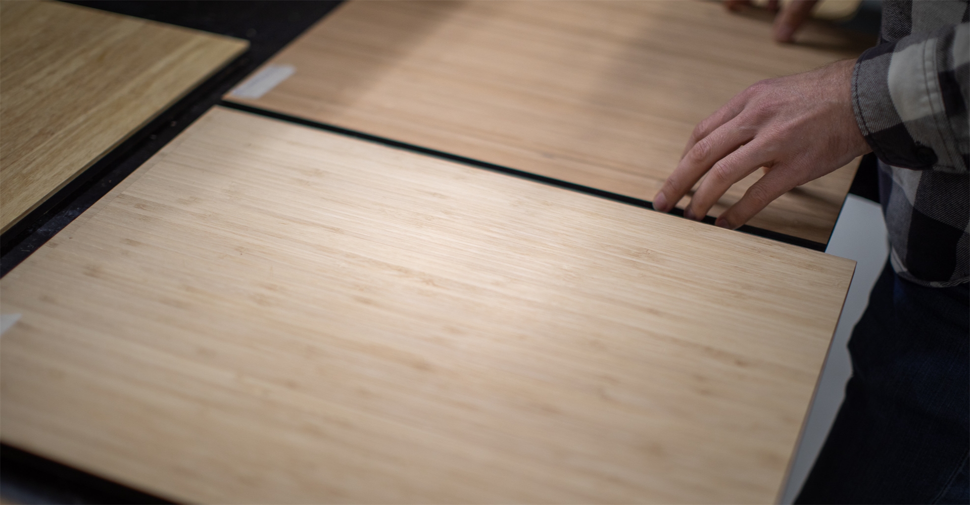 Detail van het Outbase-logo op houten keukenmodule in elektrische camperbus, met focus op duurzaam design en afwerking.