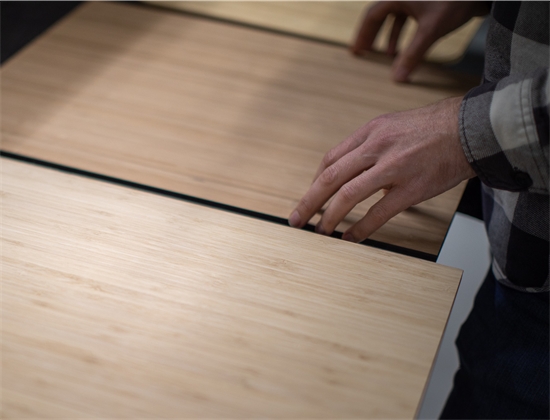 Hand selecteert duurzaam bamboe paneel voor het interieur van een compacte camperbus