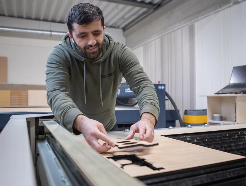Medewerker snijdt onderdelen uit op de CNC-machine