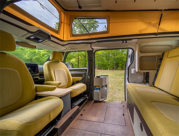  Interieur van een compacte camperbus met draaibare stoelen en slimme ingebouwde keukenoplossing
