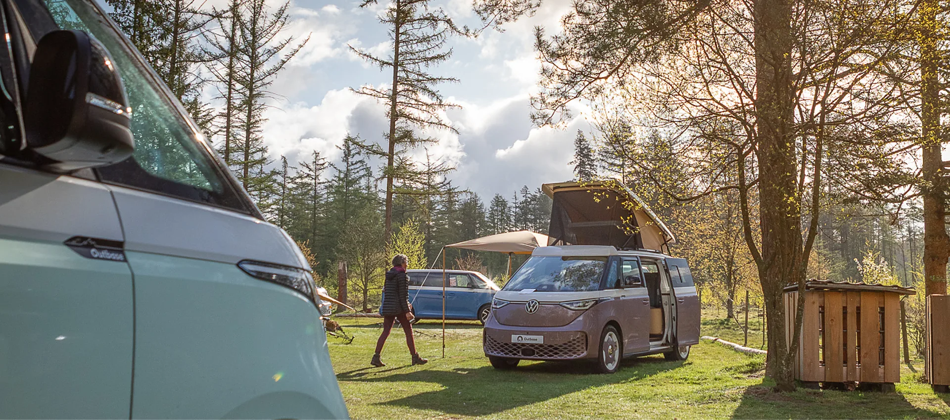 Outbase campervans on a camping field at sunset